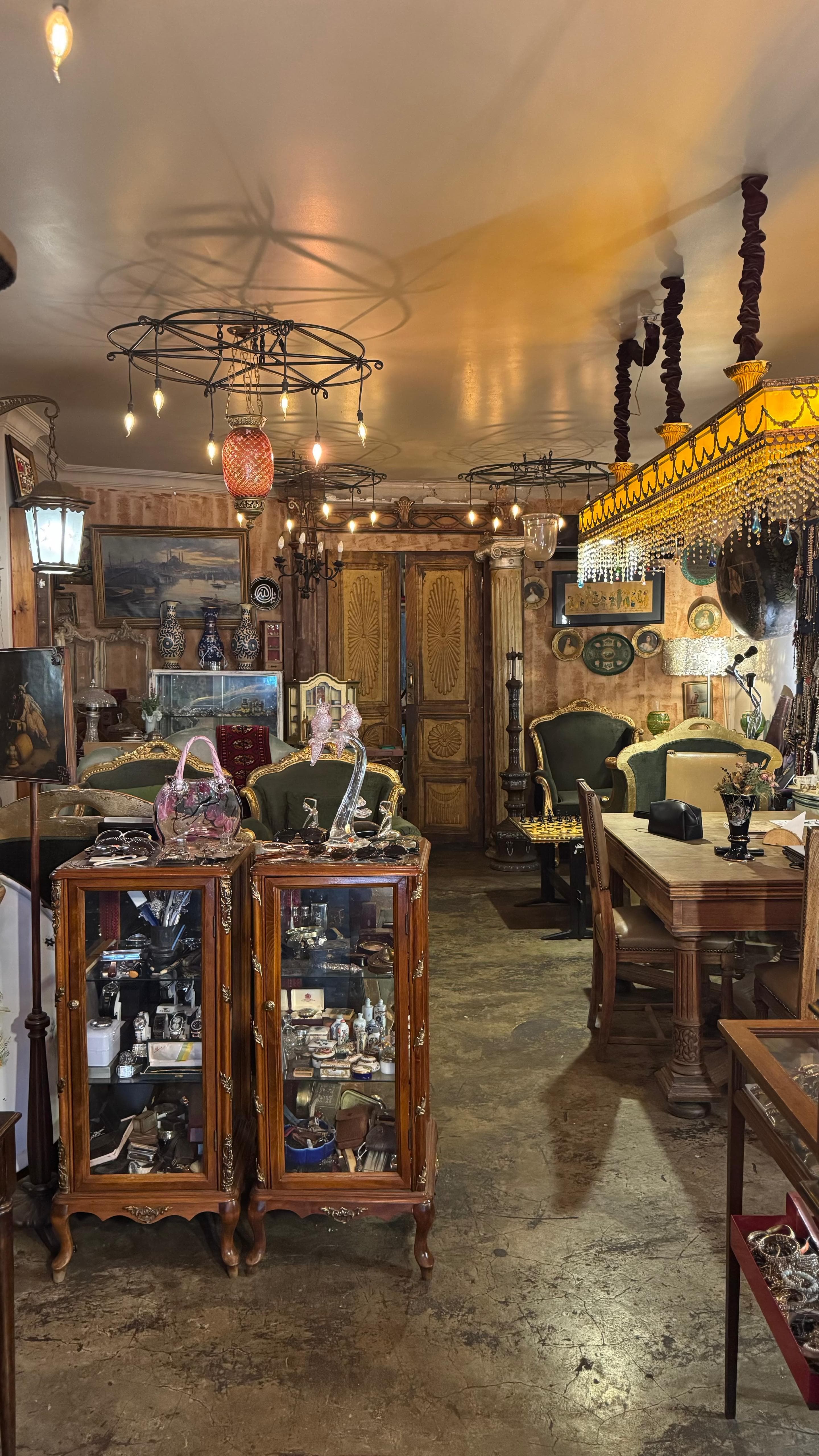 A warm interior of chandeliers, display cabinets and old timber